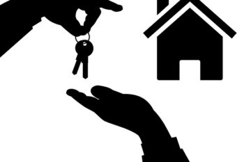 Hands passing keys to a new home.
